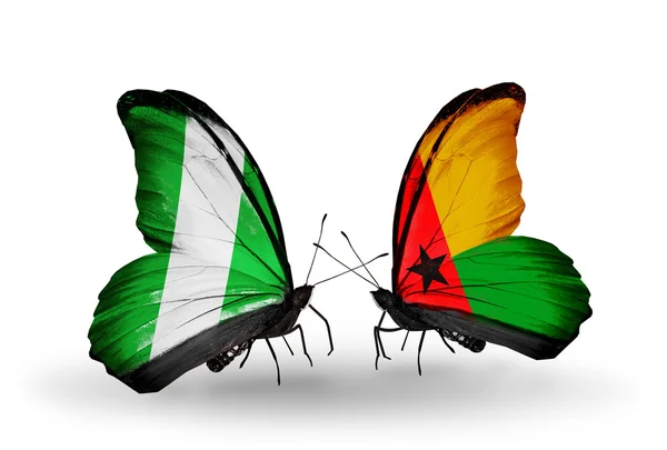 Mariposas con banderas de Nigeria y Guinea Bissau en alas — Foto de Stock