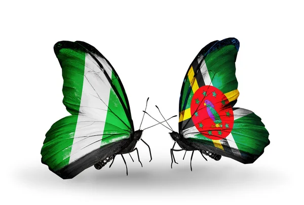 Vlinders met nigeria en dominica vlaggen op vleugels — Stockfoto