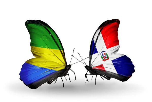 Mariposas con banderas de Gabón y Dominicana en alas — Foto de Stock