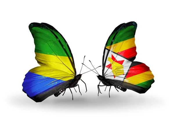 Fjärilar med gabon och zimbabwe flaggor på vingar — Stockfoto