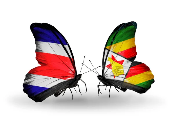 Kosta Rika ve Zimbabve bayrağı kanatlar üzerinde kelebekler — Stok fotoğraf