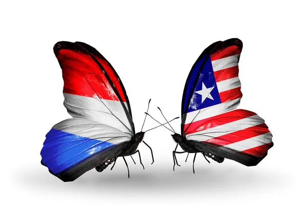 Motýli s Lucemburskem a Libérie vlajky na křídlech — Stock fotografie