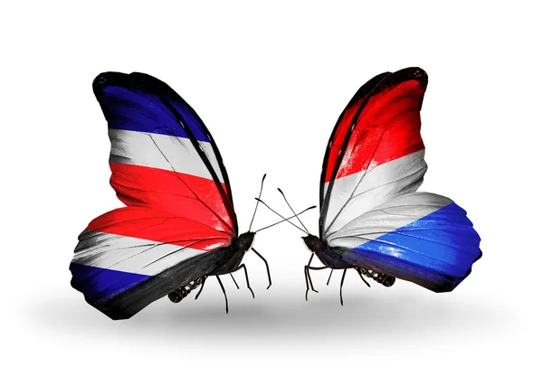 Kosta Rika ve Lüksemburg bayrakları kanatlar üzerinde kelebekler — Stok fotoğraf