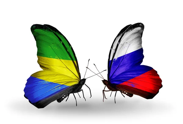 Vlinders met gabon en Rusland vlaggen op vleugels — Stockfoto