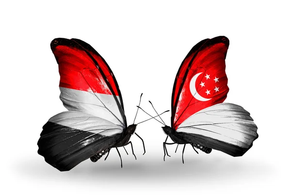 Butterflies with Yemen and Singapore flags on wings — Stock Photo, Image