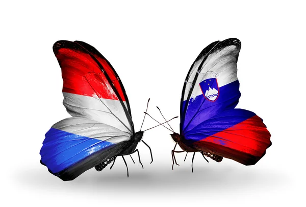 Schmetterlinge mit luxemburgischen und slowenischen Flaggen auf Flügeln — Stockfoto
