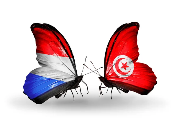 Borboletas com bandeiras de Luxemburgo e Tunísia sobre asas — ストック写真