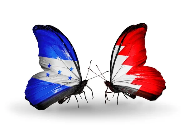 Motýli s Hondurasem a Bahrajn vlajky na křídlech — Stock fotografie