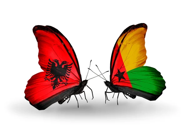 Mariposas con banderas de Albania y Guinea Bissau — Foto de Stock