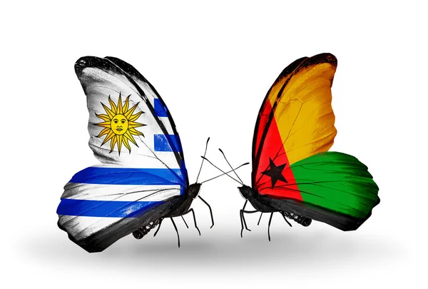 Butterflies with Uruguay and Guinea Bissau flags — Stock Photo, Image