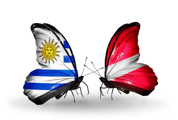 Borboletas com bandeiras do Uruguai e da Letónia — Fotografia de Stock
