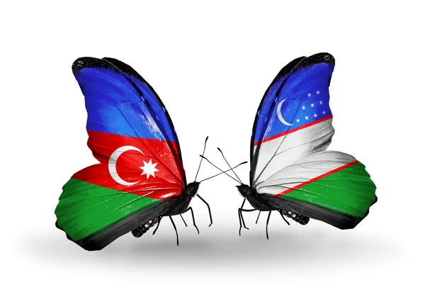Две бабочки с флагами Азербайджана и Узбекистана — стоковое фото
