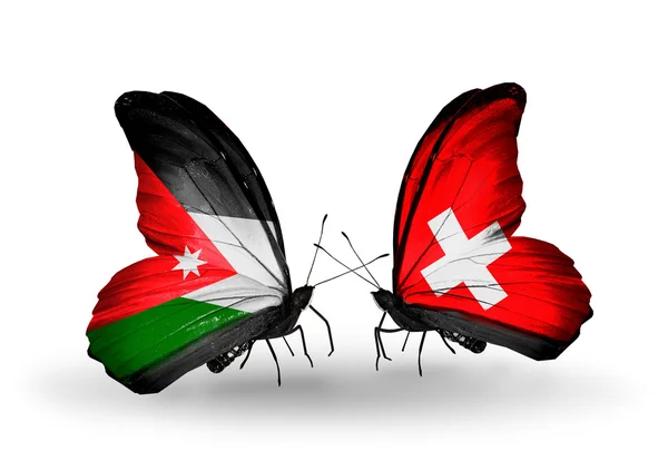 Две бабочки с флагами Иордании и Швейцарии — стоковое фото