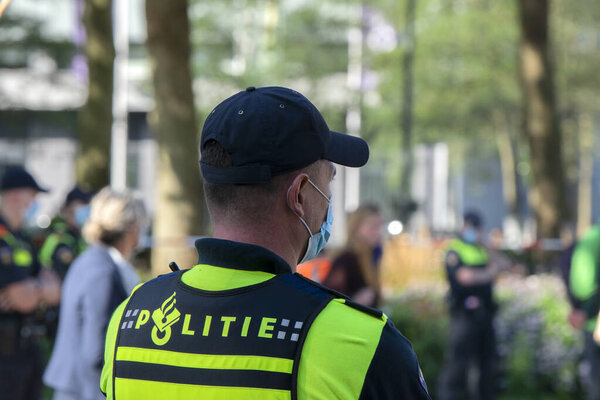 Полицейский сзади охраняет демонстрантов Демонстрация восстания Вымирания в Амстердаме Юг Нидерландов 21-9-2020