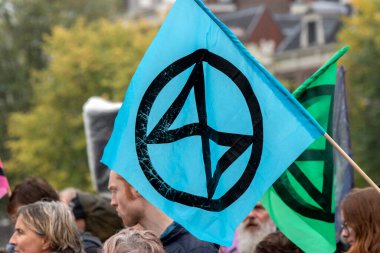 Hollanda 2019 'da, Amsterdam' daki Yok Olma İsyanı 'nın iklim gösterisinde Blauwebrug' da bir bayrağın üzerinde logo.