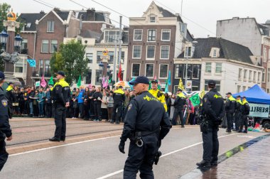 Polis Blauwebrug 'daki gösteriyi Amsterdam' daki yok oluş gösterisinden izliyor. Hollanda 2019. polisi Blauwebrug 'daki iklim gösterisini izliyor.