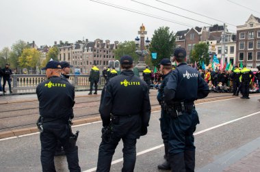 Polis Blauwebrug 'daki gösteriyi Amsterdam 2019' daki yok oluş isyan grubundan izliyor.