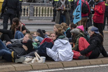 Protestocular, Hollanda 2019 'da Amsterdam' daki yok oluş isyanının iklim gösterisinde Blauwebrug 'da bir arada durdular.