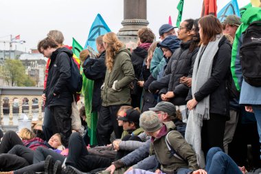 Protestocular, Hollanda 2019 'da Amsterdam' daki yok oluş isyanının iklim gösterisinde Blauwebrug 'da bir arada durdular.