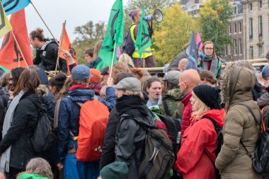 Protestocular, Hollanda 2019 'da Amsterdam' daki yok oluş isyanının iklim gösterisinde Blauwebrug 'da bir arada durdular.