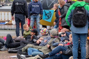 Protestocular, Hollanda 2019 'da Amsterdam' daki yok oluş isyanının iklim gösterisinde Blauwebrug 'da bir arada durdular.
