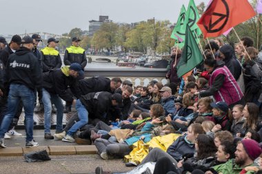 Protestocular, Hollanda 2019 'da Amsterdam' daki yok oluşun ardından Blauwebrug 'da iklim gösterisinde yerde yatıyorlar.