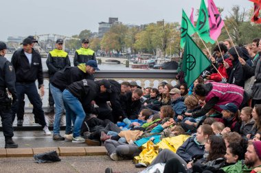 Protestocular, Hollanda 2019 'da Amsterdam' daki yok oluşun ardından Blauwebrug 'da iklim gösterisinde yerde yatıyorlar.