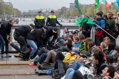Protestocular, Hollanda 2019 'da Amsterdam' daki yok oluşun ardından Blauwebrug 'da iklim gösterisinde yerde yatıyorlar.