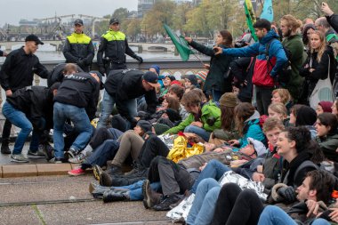 Protestocular, Hollanda 2019 'da Amsterdam' daki yok oluşun ardından Blauwebrug 'da iklim gösterisinde yerde yatıyorlar.