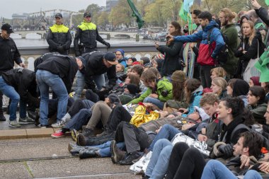 Protestocular, Hollanda 2019 'da Amsterdam' daki yok oluşun ardından Blauwebrug 'da iklim gösterisinde yerde yatıyorlar.