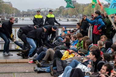 Protestocular, Hollanda 2019 'da Amsterdam' daki yok oluşun ardından Blauwebrug 'da iklim gösterisinde yerde yatıyorlar.
