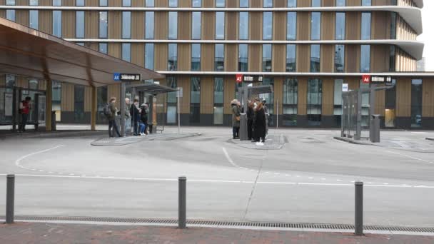アムステルダム駅でバスが到着するのを待っている人々 オランダ2019 — ストック動画