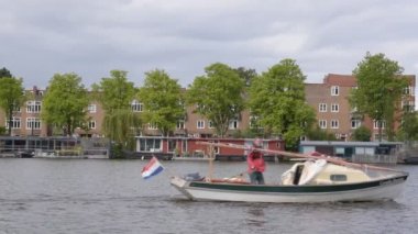Amsterdam Amstel Nehri 'nden geçen küçük tekne. Hollanda 2020.