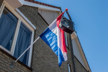 Hollanda 2018 'de Amsterdam' da bayraktaki okul çantası. Hollanda Okul Sınavlarını Geçme Geleneği.