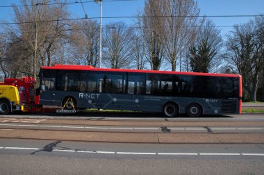 Hollanda 23-3-2022, Amsterdam 'da bir otobüsü yan görüntülü çekici çekiyor.