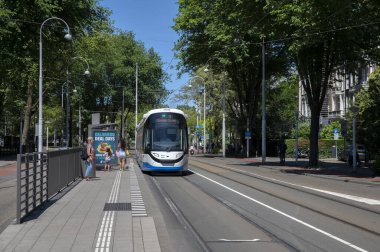 Tramvay Amsterdam 'da bir tren durağında duruyor Hollanda 22-6-2022