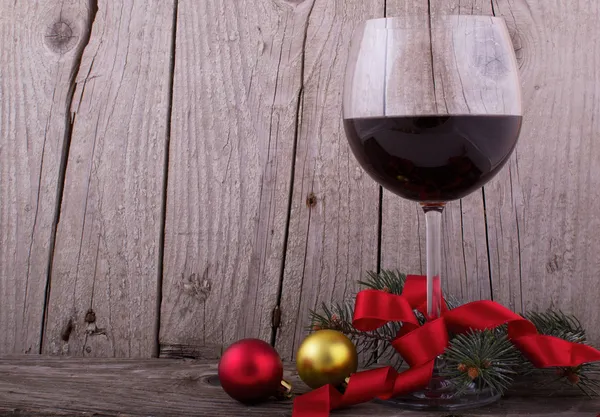 Бокал красного вина с рождественским декором на деревянном столе — стоковое фото