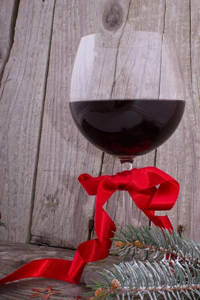 Red wine glass with Christmas decoration on the wooden table — Stock Photo, Image