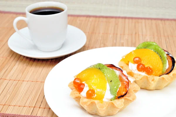 Fruit cake on a plate and a cup of coffee — Stock Photo, Image