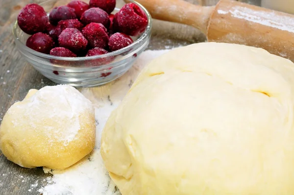 Dough, rolling pin and mincemeat cherries — Stock Photo, Image