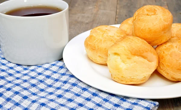 Profiteroles and a cup of tea — Stock Photo, Image