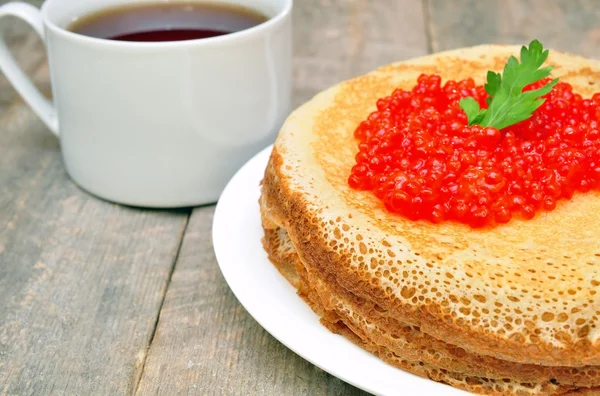 Pfannkuchen mit rotem Kaviar und einer Tasse Tee — Stockfoto