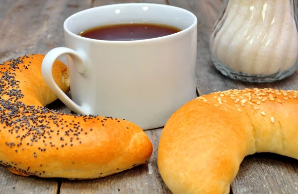 Bagel com sementes de papoila e uma xícara de chá — Fotografia de Stock