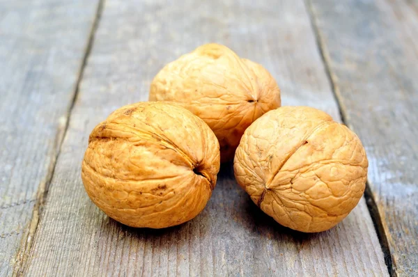 Tres nueces sobre una mesa de madera —  Fotos de Stock