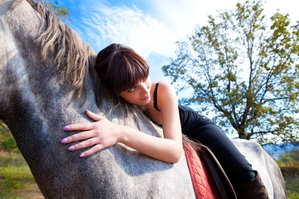 Sensual girl leaned over the horse neck — Stock Photo, Image