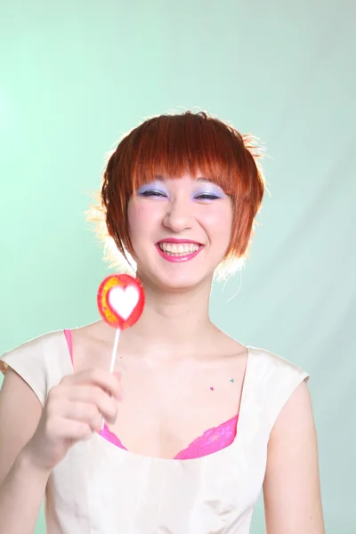 Rindo menina com cabelo vermelho com doces — Fotografia de Stock