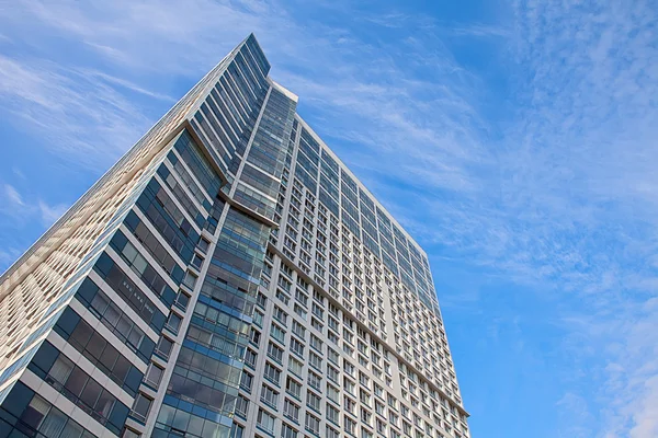 Edificio a grattacielo sullo sfondo del cielo blu con nuvole di cirri — Foto Stock