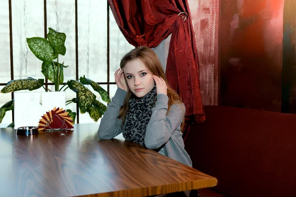 Jong meisje aan het venster restaurant tafel — Stockfoto