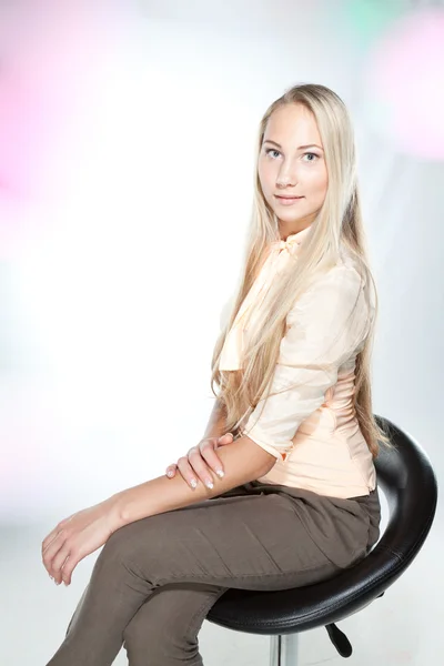 Blondýna v kanceláři oblečení na židli — Stock fotografie