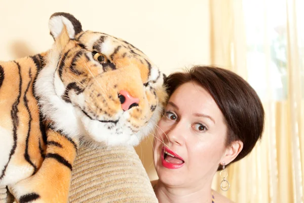 Menina alegre com um tigre de brinquedo — Fotografia de Stock